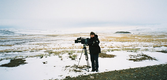 [Mike filming in countryside]